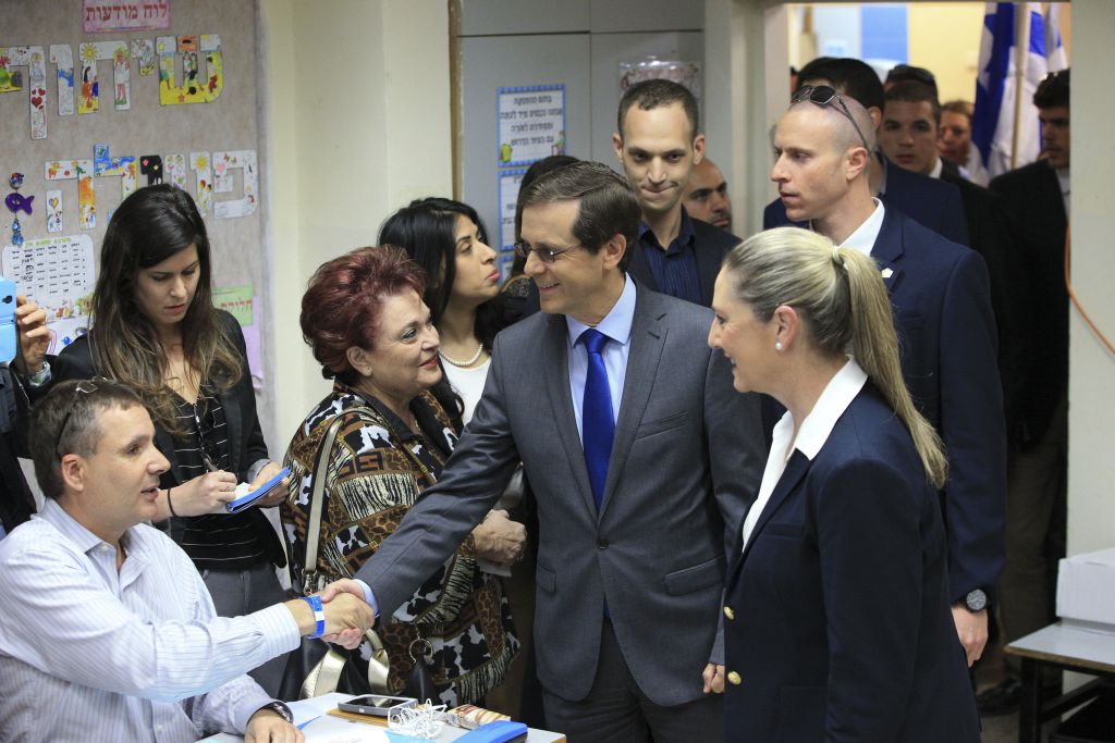 Zionist Union leader Isaac Herzog accompanied by his wife Michal prepares to cast his vote in Tel Aviv, Israel, Tuesday, March 17, 2015. (photo credit: AP Photo/Ariel Schalit)