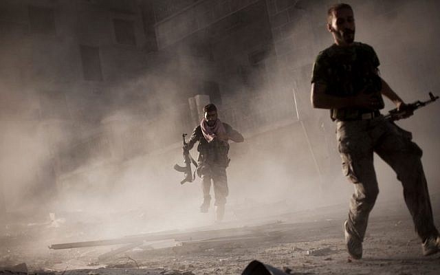 Free Syrian Army fighters run after attacking a Syrian Army tank during fighting in the Izaa district of Aleppo, Syria, on September 7, 2012. (AP/Manu Brabo, File)