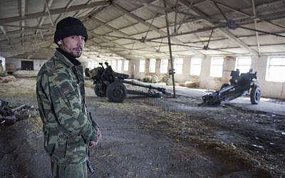 A pro-Russian rebel stands on guard in a storage for cannons in the village of Novoamvrosiivske, eastern Ukraine, Friday, March 20, 2015. (AP Photo/Mstyslav Chernov)