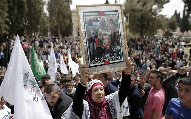 A Palestinian woman holds a portrait of a prisoner during a rally marking Palestinian Prisoners Day outside the Dome of the Rock at the Al-Aqsa mosque compound in Jerusalem's Old City, on April 17, 2015.  (Photo credit: AFP / AHMAD GHARABLI)