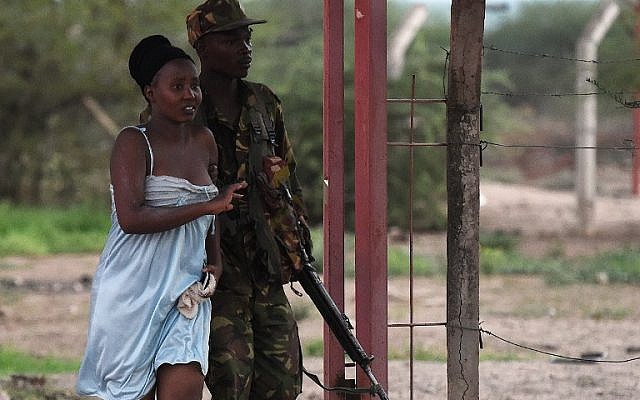 A member of the security forces escorts a student off the campus of Garissa University College after an attack by Somalia's al-Qaeda-linked al-Shabab gunmen, April 2, 2015. (photo credit: AFP/Carl de Souza)