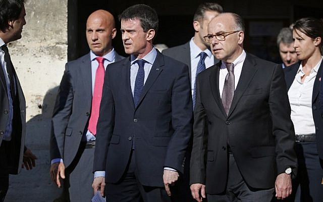 French Prime Minister Manuel Valls (C) and French Interior Minister Bernard Cazeneuve (R) leave a church in Villejuif, outside Paris, on April 22, 2015. (photo credit: AFP PHOTO / KENZO TRIBOUILLARD)