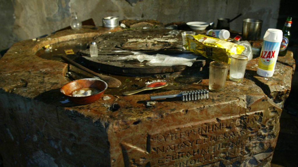 Dirty dishes, hair brushes, cleansers, and other personal items are left on top of an ancient pedestal in the Basilica of the Church of the Nativity after the end of the five-week siege in Bethlehem Friday, May 10, 2002. (AP Photo/Charles Dharapak)