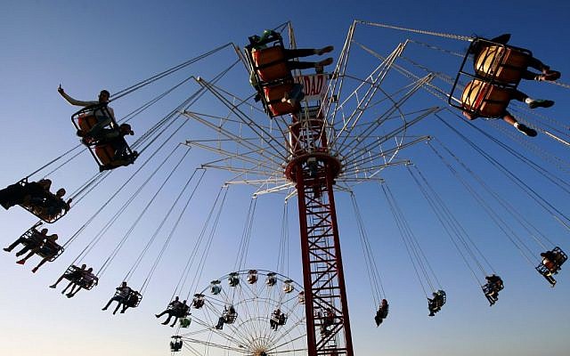 Palestinians enjoy a ride in an amusement park during the Eid al-Adha holiday, in the West Bank city of Jenin, Oct. 5, 2014. (photo credit: AP Photo/Mohammed Ballas)