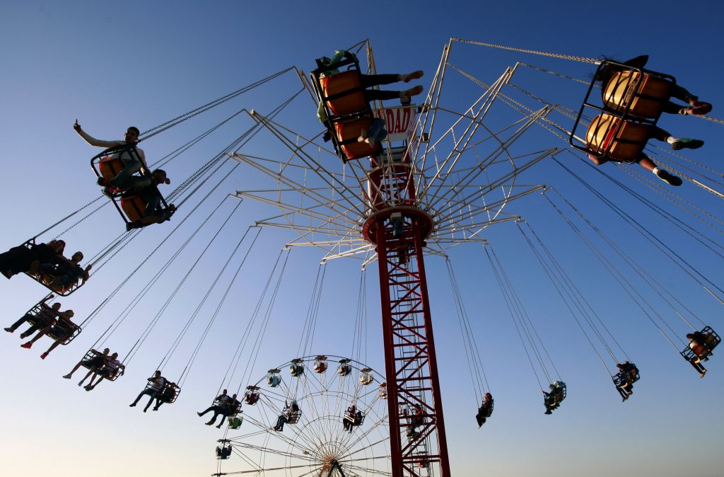 Palestinians enjoy a ride in an amusement park during the Eid al-Adha holiday, in the West Bank city of Jenin, Oct. 5, 2014. (photo credit: AP Photo/Mohammed Ballas)