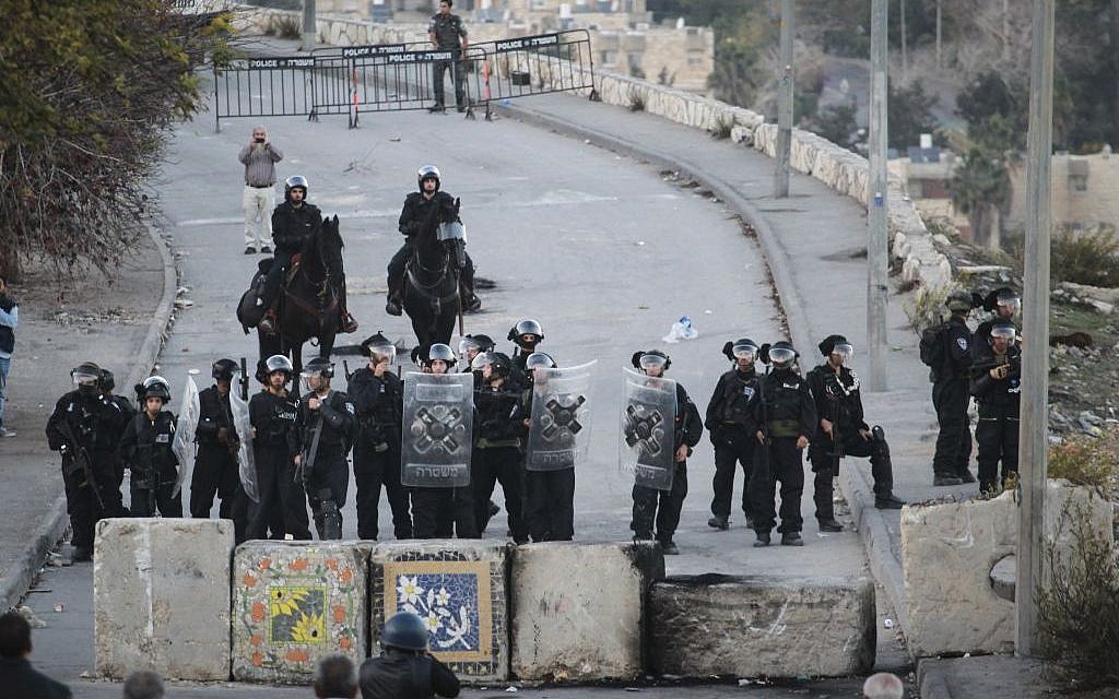 Israeli Border Police stand guard next to new cement blocks placed at the entrance to Issawiya in East Jerusalem during a demonstration against the neighborhood's closure, November 12, 2014 (photo credit: Hadas Parush/Flash90)