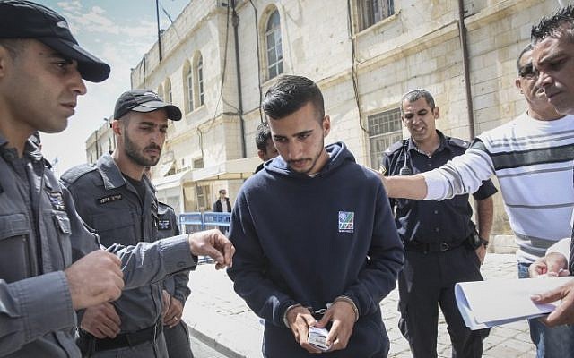 Niv Asraf (center), a 22-year-old from Beersheba, is seen at the Jerusalem Magistrate's Court on April 3, 2015, a morning after he was found in Kiryat Arba after being falsely reported as missing. (Hadas Parush/Flash90)