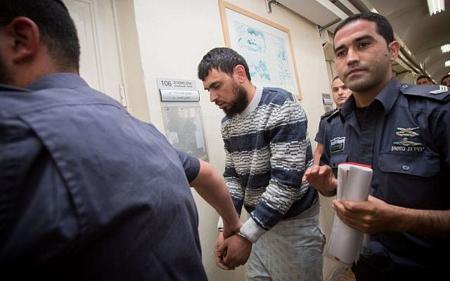 Police escort Khaled Koutineh, who rammed his car into Israeli pedestrians, to a hearing at the Magistrate's Court in Jerusalem. April 16, 2015. (photo credit: Miriam Alster/FLASH90)
