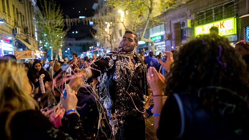 Israelis play with "snow spray", on the streets of Jerusalem, as Israel's celebrates its 67th Independence Day on April 22, 2015. (Photo credit: Yonatan Sindel/Flash90)