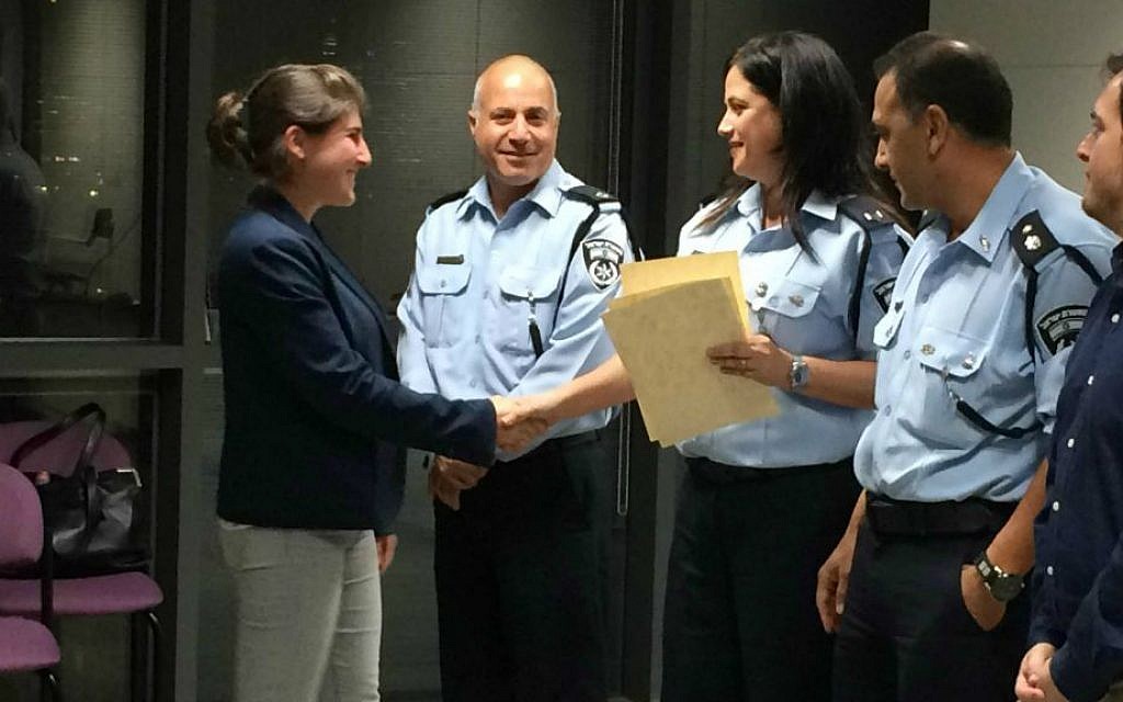 Recent immigrant Harriet Shakked receives her Civil Guard graduation certificate from course commander Police Officer Mirit Hadar, Tel Aviv, April 16, 2015. (photo credit: Renee Ghert-Zand/Times of Israel staff)
