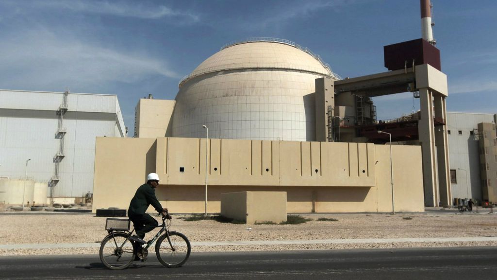 A worker rides a bicycle in front of the reactor building of the Bushehr nuclear power plant, just outside the southern city of Bushehr, Iran, on October 26, 2010. (AP/Mehr News Agency, Majid Asgaripour, File)