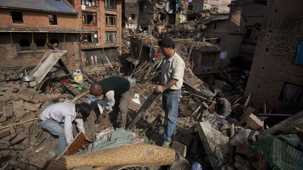 A Nepalese family collects belongings from their home destroyed in Saturday's earthquake, in Bhaktapur on the outskirts of Kathmandu, Nepal, Monday, April 27, 2015. (photo credit: AP/Niranjan Shrestha)