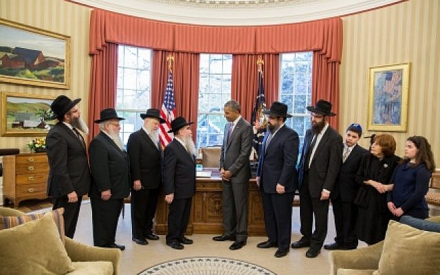 President Barack Obama presents a ceremonial copy of the Education and Sharing Day Proclamation that he issued on March 31, 2015 to a delegation from the American Friends of Lubavitch in the Oval Office, April 27, 2015. (Photo credit: Pete Souza/White House)