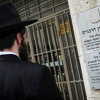 Illustrative: A man stands outside the Jerusalem Rabbinical Court. (Miriam Alster/Flash90)