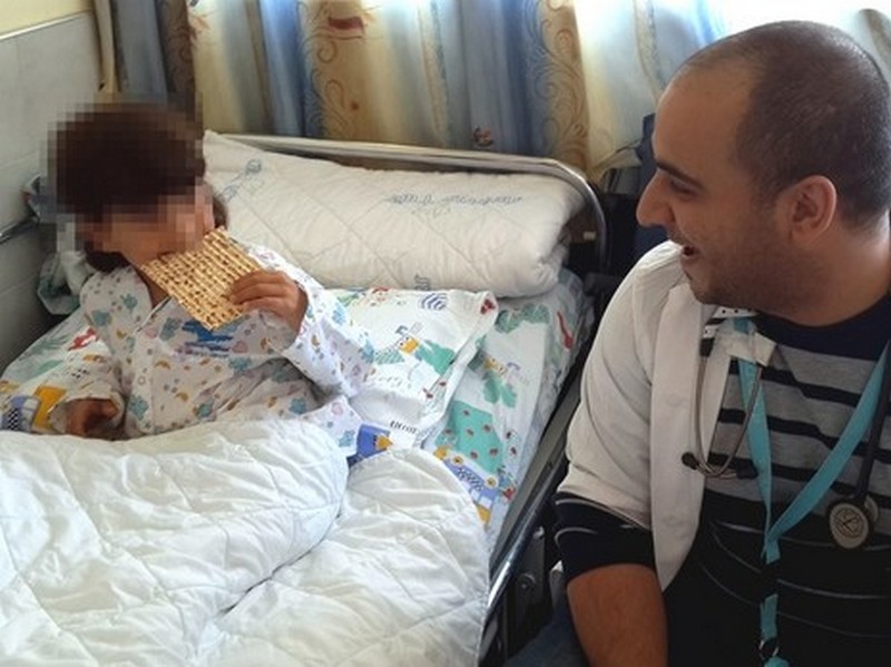 A Syrian boy hospitalized in Israel has his first taste of matza on Tuesday, April 7, 2015 (photo credit: courtesy Ziv Hospital)