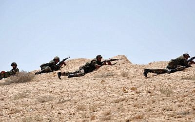 Syrian soldiers get in position during clashes with Islamic State jihadists in northeastern Palmyra on May 17, 2015. (AFP/STR)
