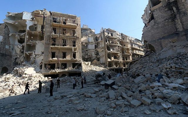 Syrians stand amid the destruction in the eastern Shaar neighborhood of the northern Syrian city of Aleppo on May 30, 2015. (AFP/AMC/ZEIN AL-RIFAI)