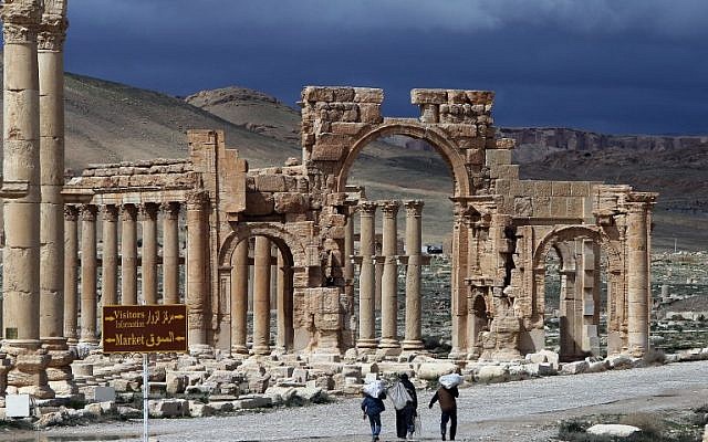 Syrian citizens walking in the ancient oasis city of Palmyra on March 14, 2014. (AFP/JOSEPH EID)