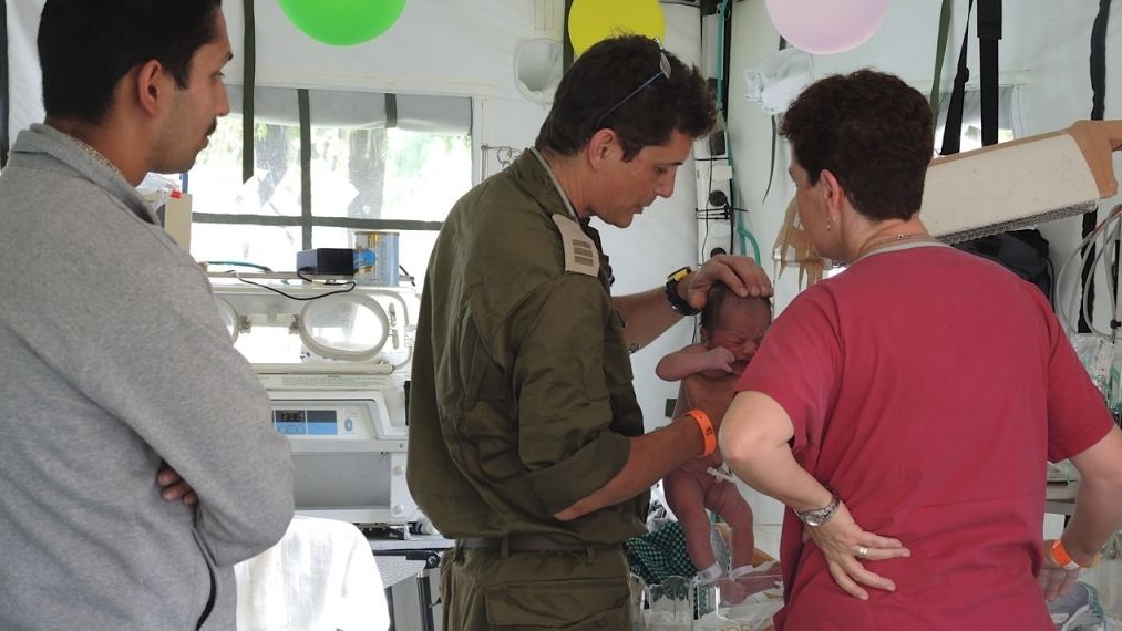 Doctors examine baby Chand just a few hours after her birth, as father Harendra Chand looks on, May 1, 2015 (Photo credit: Melanie Lidman).