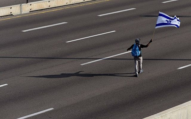 A lone flag-waver on the blocked Ayalon highway during a protest against violence and racism directed at Israelis of Ethiopian descent on May 03, 2015 (Photo credit: Ben Kelmer/FLASH90)