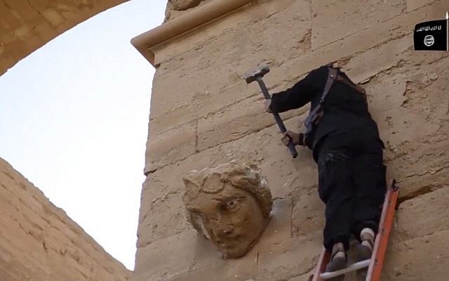 In this image made from a video posted on YouTube on April 3, 2015, a militant hammers away at a face on a wall in Hatra, a large fortified Iraqi city recognized as a UNESCO World Heritage Site. (AP, File)