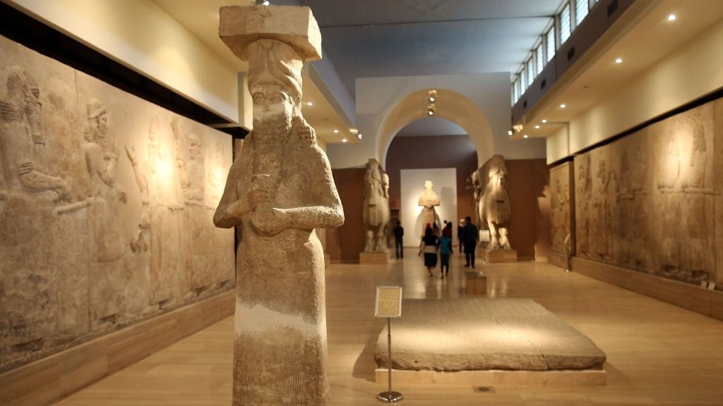 People observe ancient artifacts at the Iraqi National Museum on March 15, 2015 after its reopening in the wake of the recent destruction of Assyrian archaeological sites by the Islamic State group in Mosul, as they visit the museum in Baghdad. (Photo credit: Karim Kadim, AP)