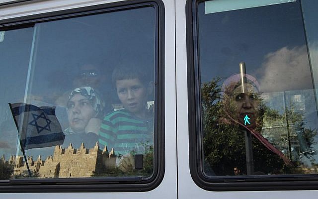 Arab women watch Jerusalem Day celebrations through their bus window, May 20, 2012 (Nati Shohat/Flash90)