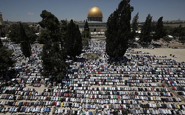 Palestinian Muslim worshipers pray outside the Dome of the Rock at the al-Aqsa compound in Jerusalem during the first Friday prayer of the holy month of Ramadan, on June 19, 2015. (AFP/Ahmad Gharabli)