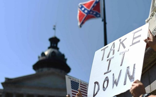 Protesters hold a sign during a rally to take down the Confederate flag at the South Carolina Statehouse, Tuesday, June 23, 2015, in Columbia, South Carolina. (AP Photo/Rainier Ehrhardt)