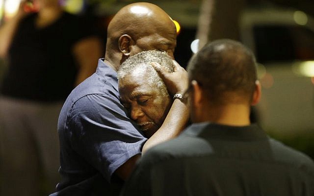 Worshippers embrace following a group prayer across the street from the scene of a shooting on June 17, 2015, in Charleston, South Carolina. (David Goldman/AP)