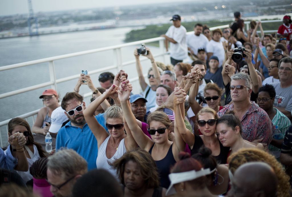 People join hands in a moment of silence as thousands of marchers meet on Charleston's main bridge in a show of unity after nine black church parishioners were gunned down during a Bible study, Sunday, June 21, 2015, in Charleston, S.C. (AP Photo/David Goldman)