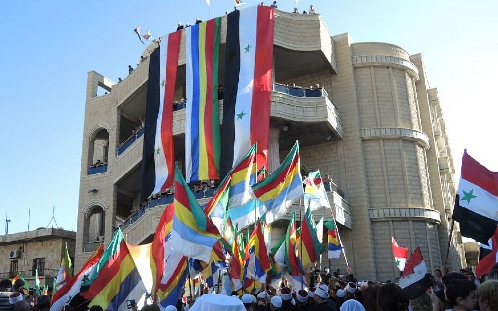 Syrian and Druze flags at a pro-Assad protest in the Druze village of Majdal Shams in the Golan Heights on Monday. (Melanie Lidman/Times of Israel)