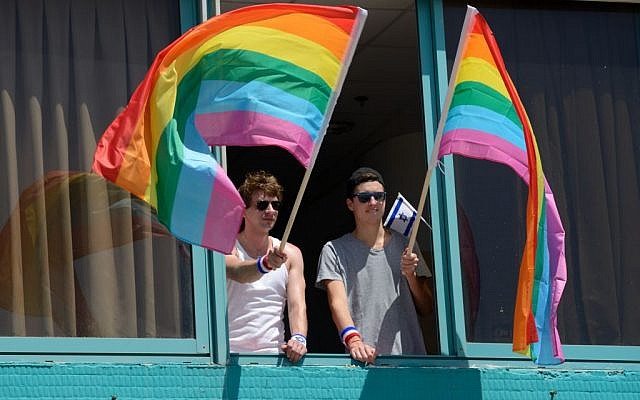 Men wave rainbow flags at the Annual Gay Pride Parade in Tel Aviv, June 12, 2015 (Flash90/Gili Yaari)