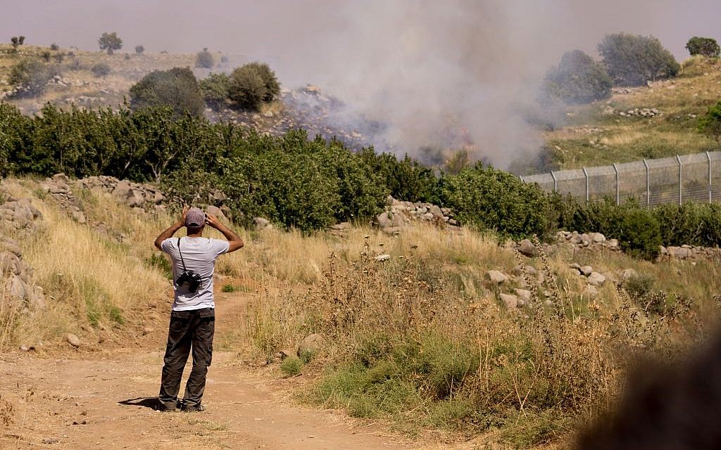 Druze watch the bombing between Syrian forces from the Israeli side of the border with Syria in the Golan Heights, on June 16, 2015. (Basel Awidat/Flash90)