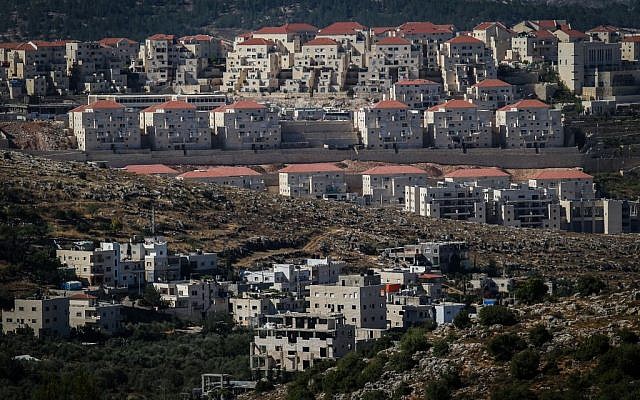Construction in the ultra-Orthodox settlement of Beitar Illit, with the Arab village of Wadi Fukin in the foreground, on June 17, 2015. (Nati Shohat/Flash90)