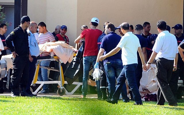 Injured people are treated near the area where a terror attack took place in Sousse, Tunisia, Friday June 26, 2015. (AP Photo/Hassene Dridi)