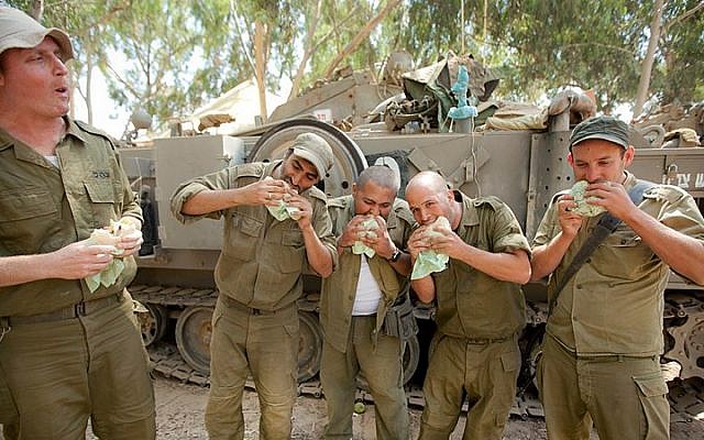 Illustrative photo: IDF reserve soldiers seen eating in a staging area near the border with Gaza in Southern Israel on July 20, 2014, during Israel's Operation Protective Edge. (Moshe Shai/Flash90)