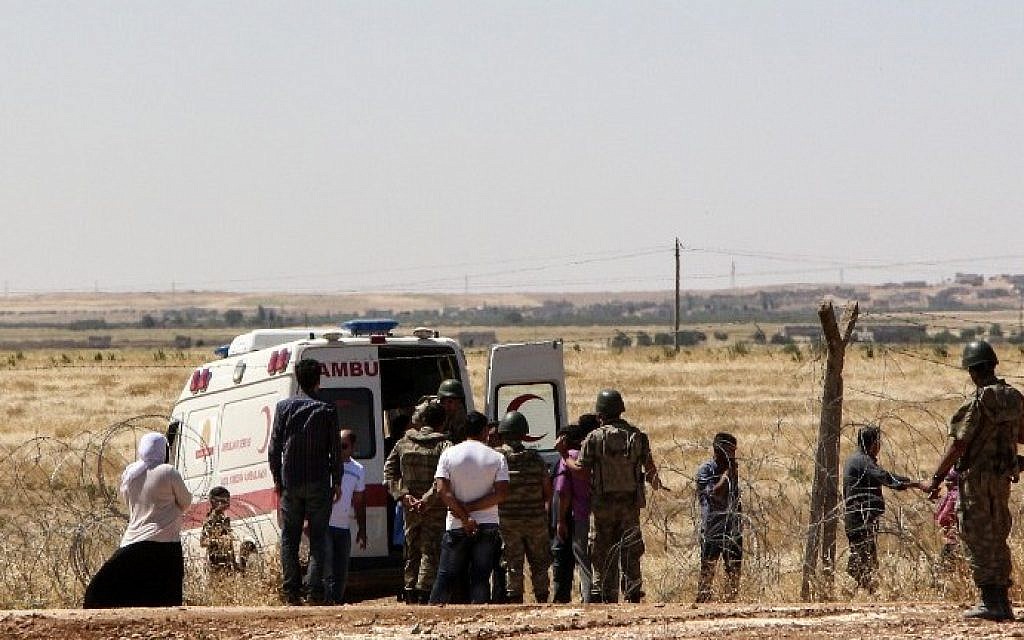 An ambulance waits in Suruc in Turkey's in Sanliurfa province to transport wounded people near the Syrian border town of Kobane on June 25, 2015. (AFP)