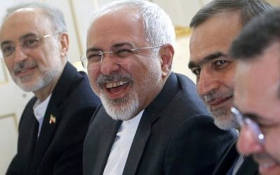Iranian Foreign Minister Javad Zarif  (C) laughs at the start of a meeting on Iran's nuclear program with US Secretary of State John Kerry in Vienna, Austria, on June 30, 2015. (AFP PHOTO/POOL/CARLOS BARRIA)