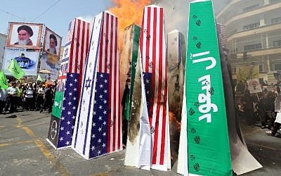 Iranian protesters burn Israeli, US and Saudi Arabian flags during a demonstration to mark the Quds (Jerusalem) International day in Tehran on July 10, 2015. (AFP/ ATTA KENARE)