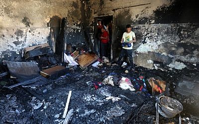 Palestinians look at the damage after a house was set on fire and a baby killed, allegedly by Jewish terrorists, in the West Bank village of Duma, on July 31, 2015. (AFP/Jaafar Ashtiyeh)