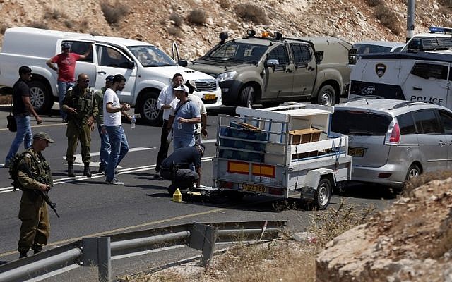 Israeli police investigate the scene of a shooting attack targeting an Israeli car on a road near the Kohav Hashahar settlement in the West Bank, July 31, 2015. (AFP Photo/ Thomas Coex)
