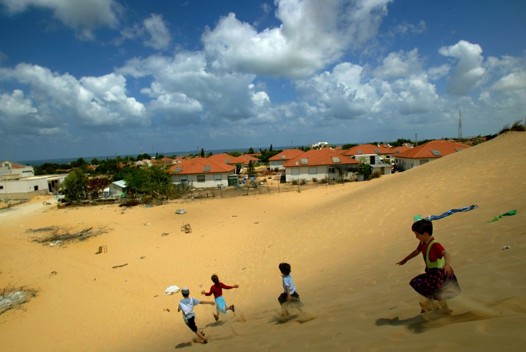 Israeli children play on a sand dune overlooking their homes in the Jewish settlement of Neve Dekalim, in the Gush Katif bloc in the southern Gaza Strip, Monday, Aug. 8, 2005. N (AP Photo/David Guttenfelder)
