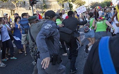 Security forces reach for an ultra-Orthodox Jew attacking people with a knife during a Gay Pride parade Thursday, July 30, 2015 in central Jerusalem. (AP Photo/Sebastian Scheiner)