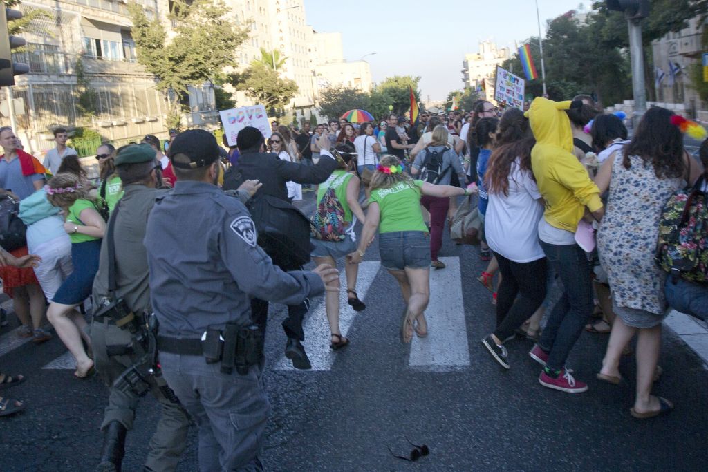Security forces reach for an ultra-Orthodox Jew, Yishai Schlissel, attacking people with a knife during a Gay Pride parade  in central Jerusalem on Thursday, July 30, 2015. (AP Photo/Sebastian Scheiner)
