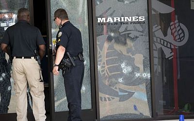 Police officers enter the Armed Forces Career Center through a bullet-riddled door after a gunman opened fire on the building in Chattanooga, Tennessee, July 16, 2015. (AP/John Bazemore) 