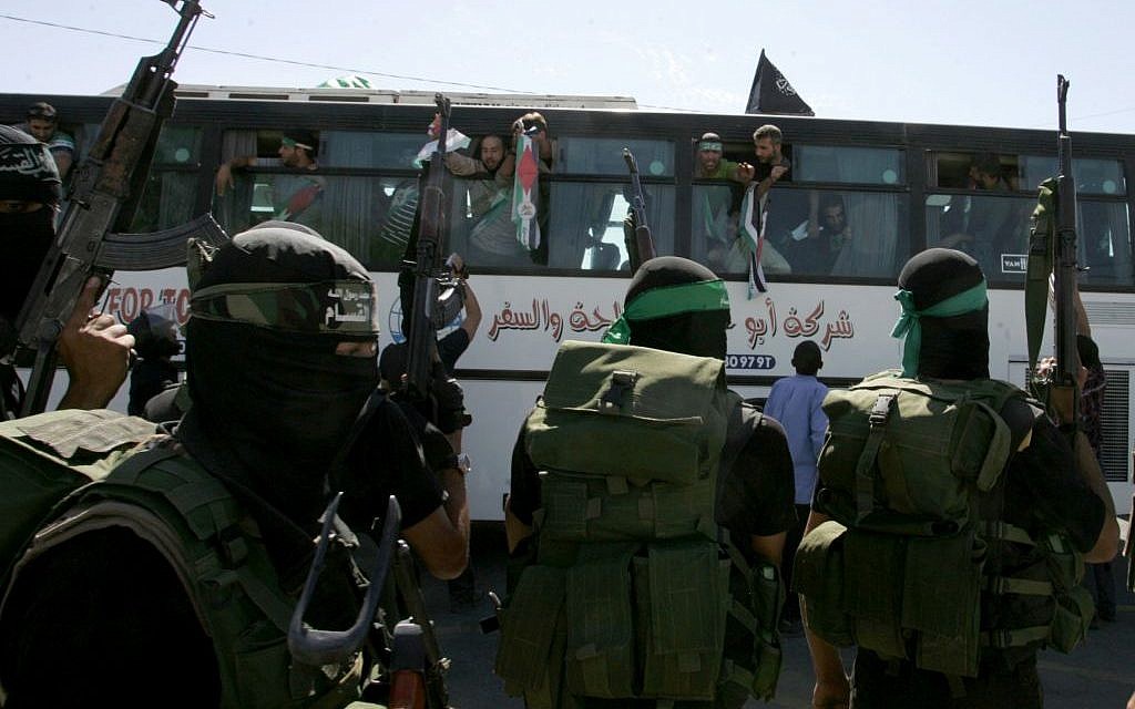Illustrative: Hamas members watch as a bus carrying Palestinian prisoners arrives at the Rafah crossing with Egypt in the southern Gaza Strip on October 18, 2011. (Abed Rahim Khatib/Flash 90)