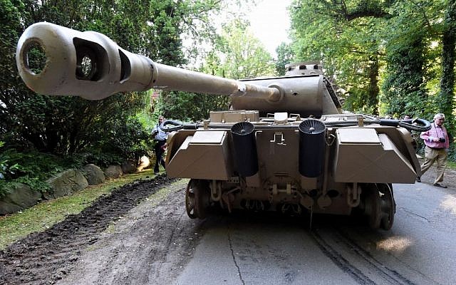 In this July 2, 2015 picture a World War II -era Panther tank is prepared for transportation from a residential property in Heikendorf, northern Germany. Authorities have seized a 45-ton Panther tank, a flak canon and multiple other World War II-era military weapons in a raid on a 78-year-old collector's storage facility in northern Germany. (Carsten Rehder/dpa via AP)