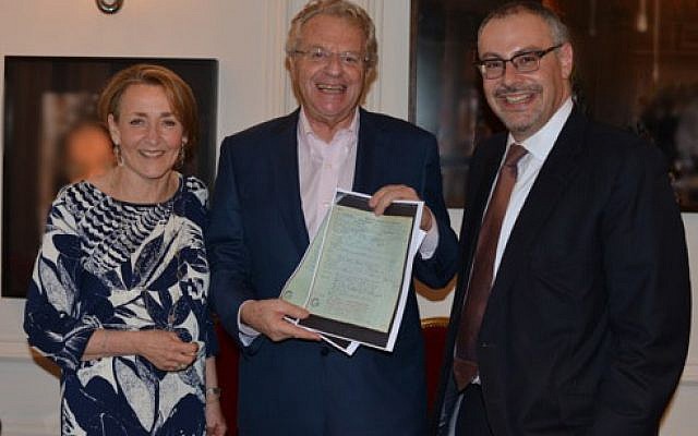 Jerry Springer (center) with his parents' documents, with Linda Rosenblatt, World Jewish Relief vice chair and James Libson, World Jewish Relief chair (Courtesy World Jewish Relief)