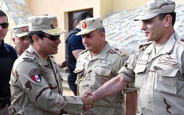 In this picture provided by the office of the Egyptian Presidency, Egyptian President Abdel-Fattah el-Sissi, second left, greets members of the Egyptian armed forces in Northern Sinai, Egypt, Saturday, July 4, 2015.(Egyptian Presidency /Mohammed Abdel-Muati via AP)